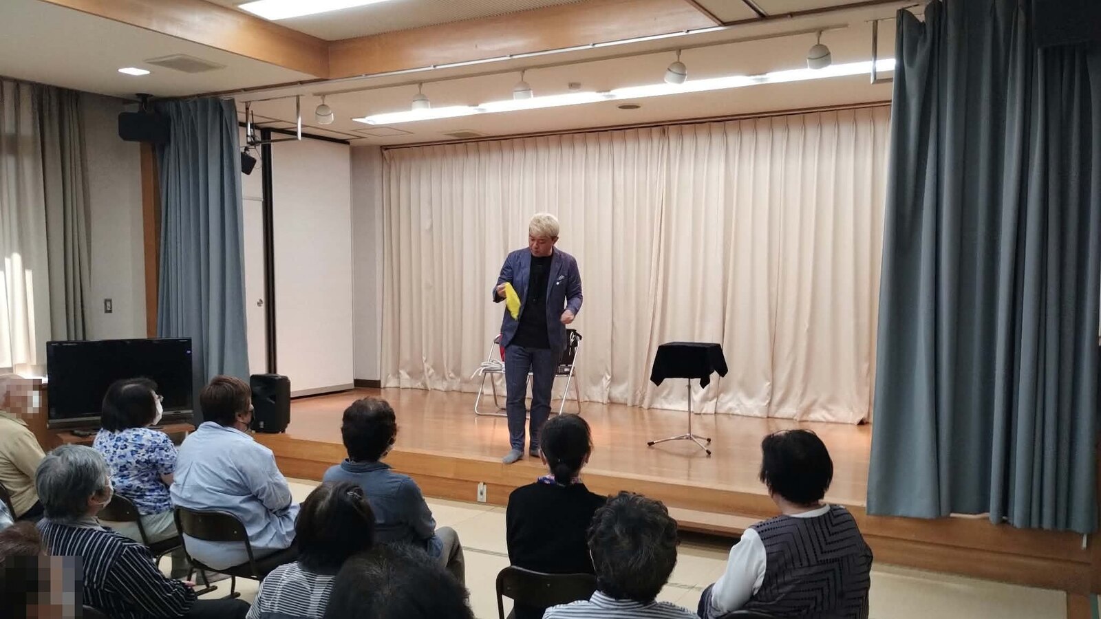 若林公民館のステージで、黄色いハンカチを手にマジックを見せるコンプレッサー