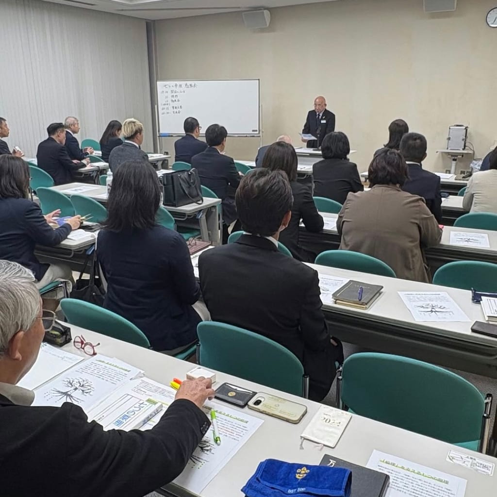 新川文化ホールの会議室で、ホワイトボードの横に立つ話し手に向かい、机にテキストや配布資料を広げて耳を傾ける勉強会の参加者