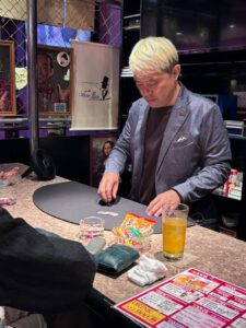 富山市桜木町 マジックバー ショーマンのカウンターで、銀貨を使ったマジックを披露するマジシャン・コンプレッサー