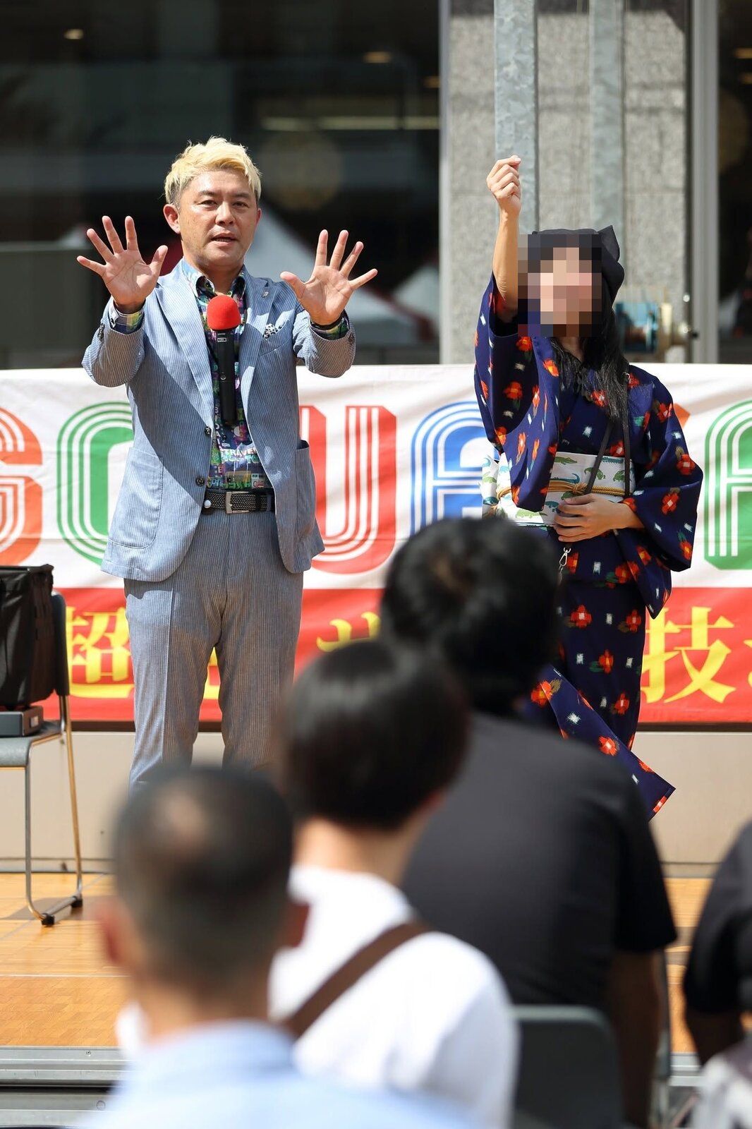スゴ技ショーVOL81のステージに上がり、マジシャン・コンプレッサーの隣で手を挙げるお手伝いのお客さん