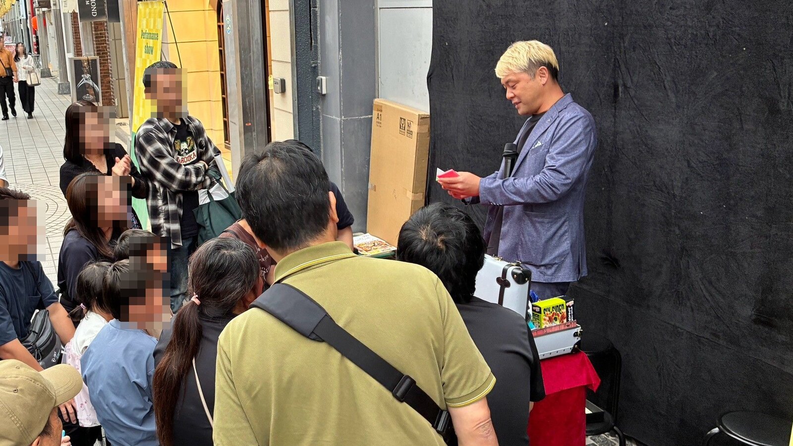 スゴ技ストリート10月、富山市総曲輪通りのアーケードで、足を止めてくださったお客さんにマジックを見せるコンプレッサー