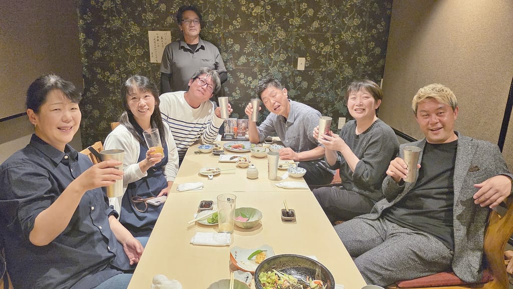 高岡のお店の個室で、高校時代の生徒会の仲間たちとグラスを掲げて笑顔で乾杯するマジシャン・コンプレッサー(右端)