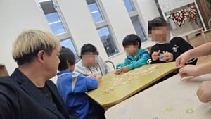 高岡シュタイナー学童保育で、楊枝が広がった机を子どもたちと囲むマジシャン・コンプレッサー