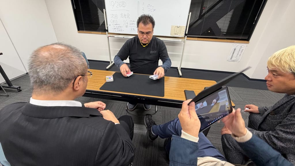 まじっぱで、2組のトランプを手に演じるメンバーと、タブレットを構えて見守るメンバーたち
