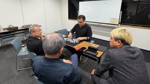 富山のマジックサークルまじっぱ131回目。「まじっくサークル まじっぱ 10/26」と書いたホワイトボードの前で、黒いマットいっぱいのポーカーチップをメンバーが囲む様子